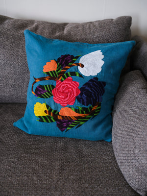 Flower pillow on blue linen