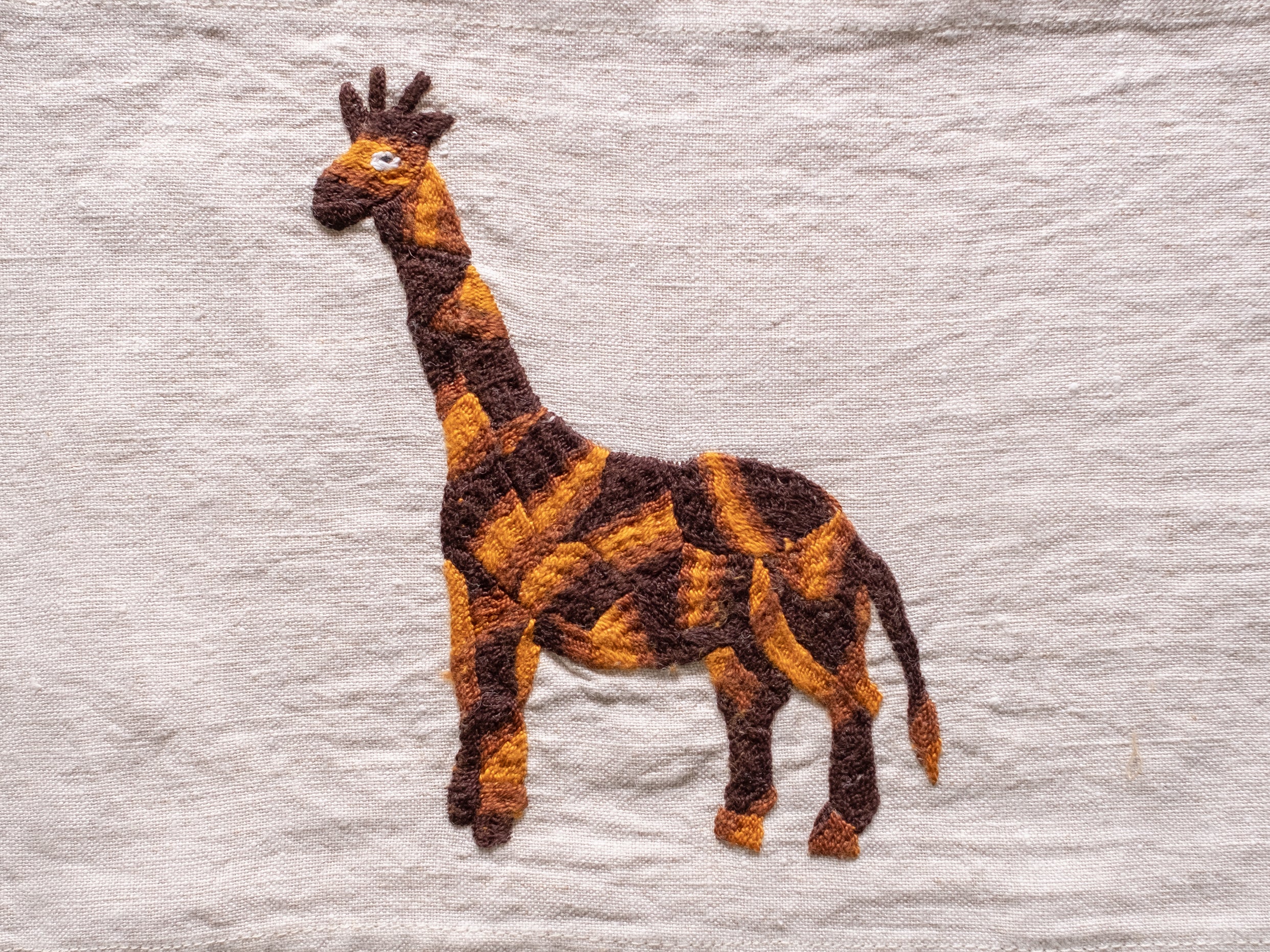 Small giraffe milaya on natural linen