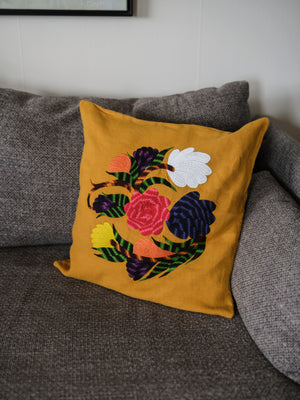 Flower pillow on yellow linen