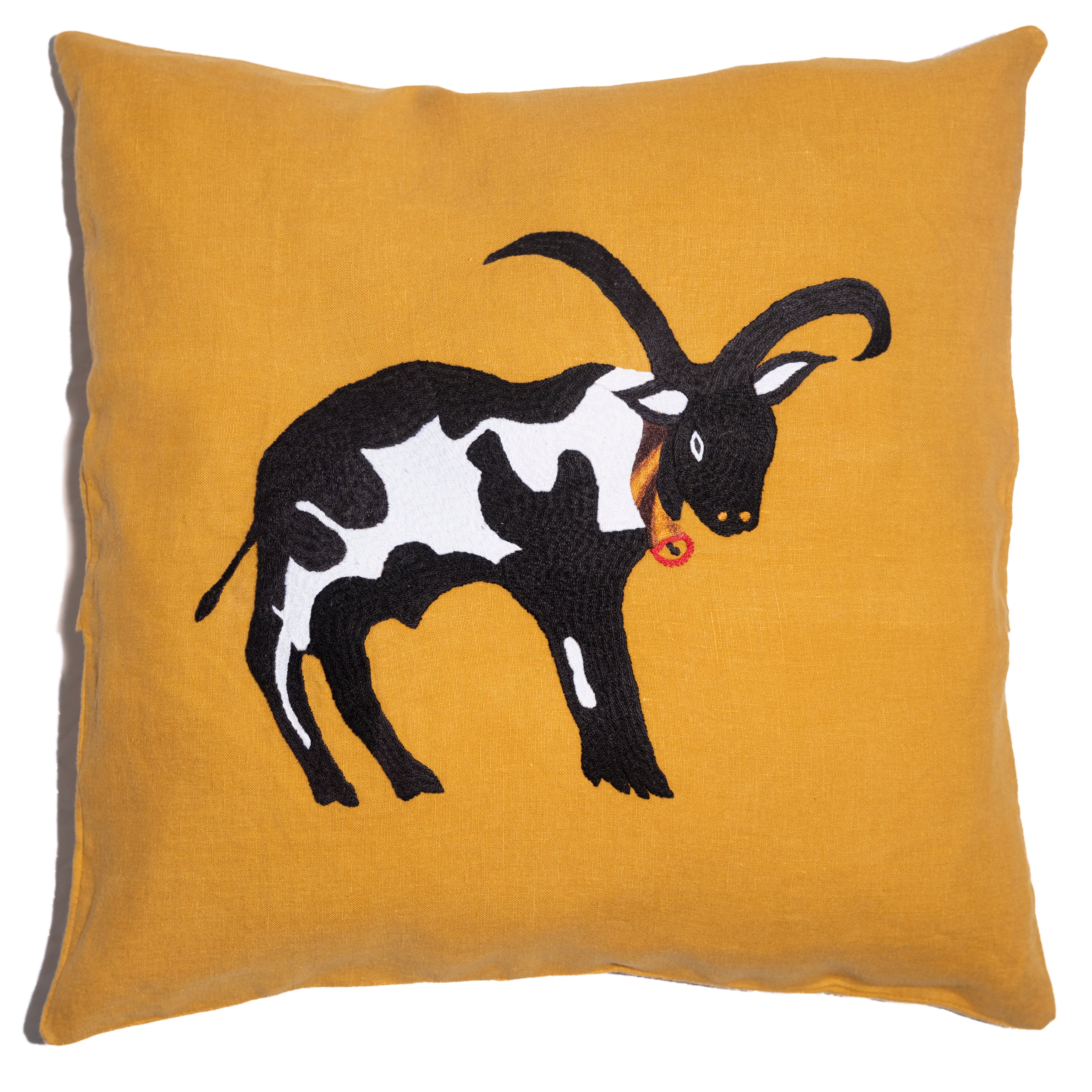 Cow pillow on yellow linen