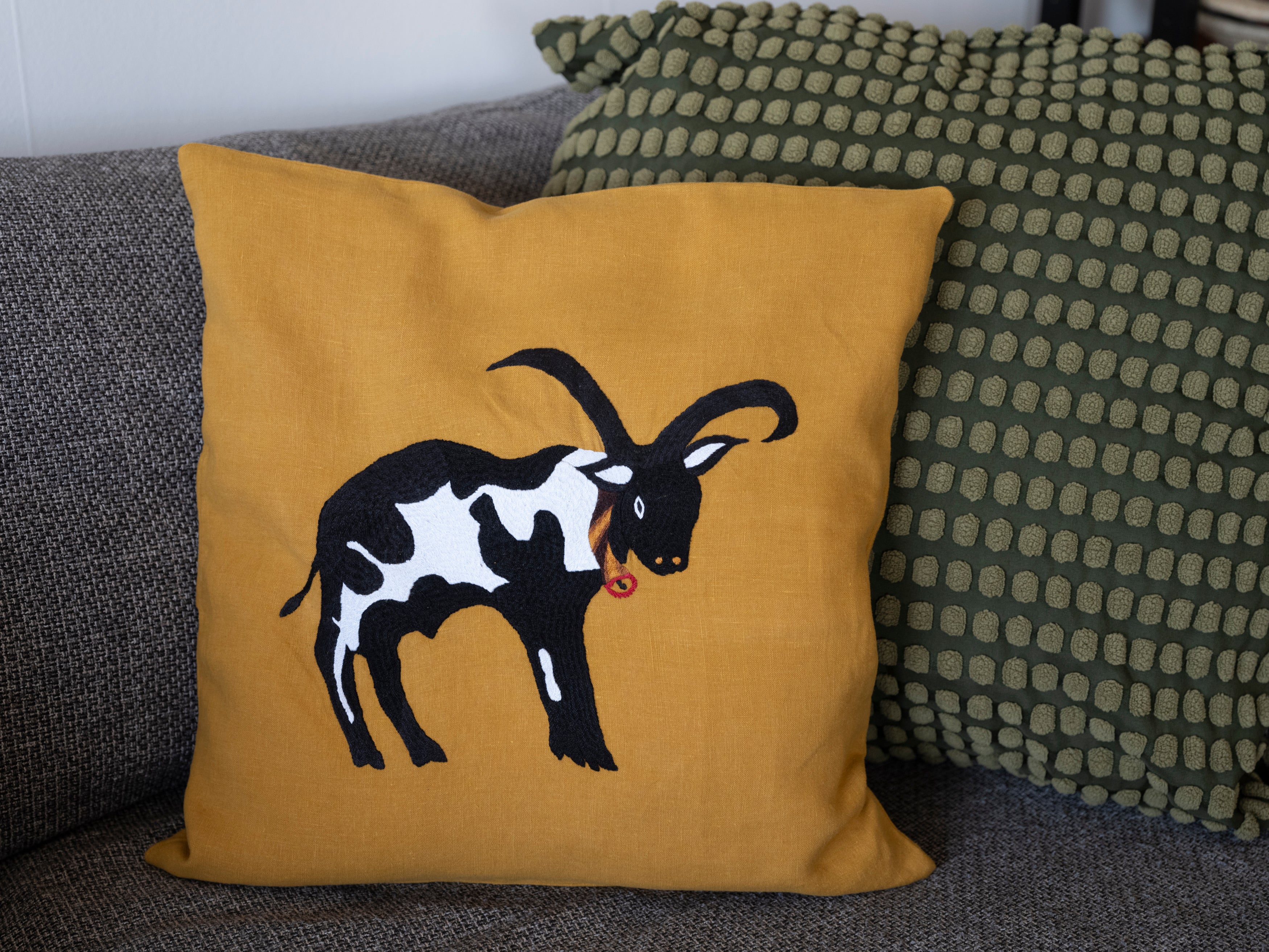Cow pillow on yellow linen