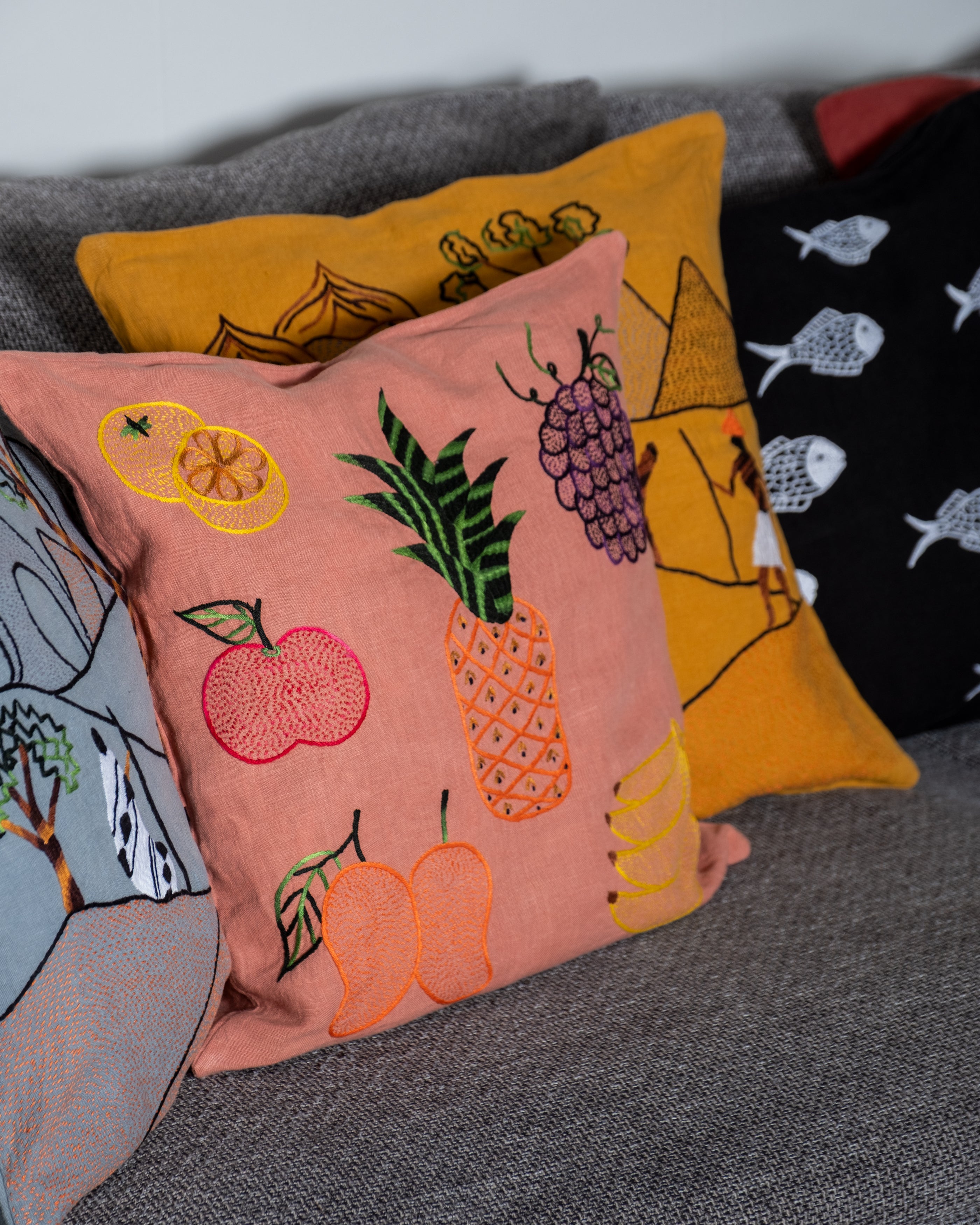 Colorful embroidered cushions on a gray surface
