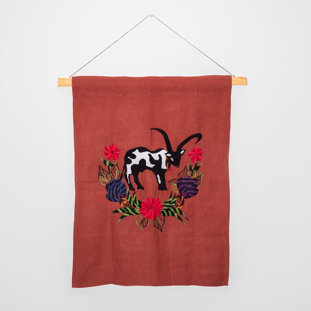 Cow wall hanging on red linen