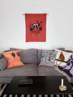 Cow wall hanging on red linen