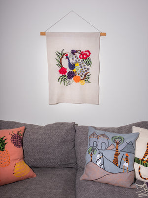 Peacock wall hanging on natural linen
