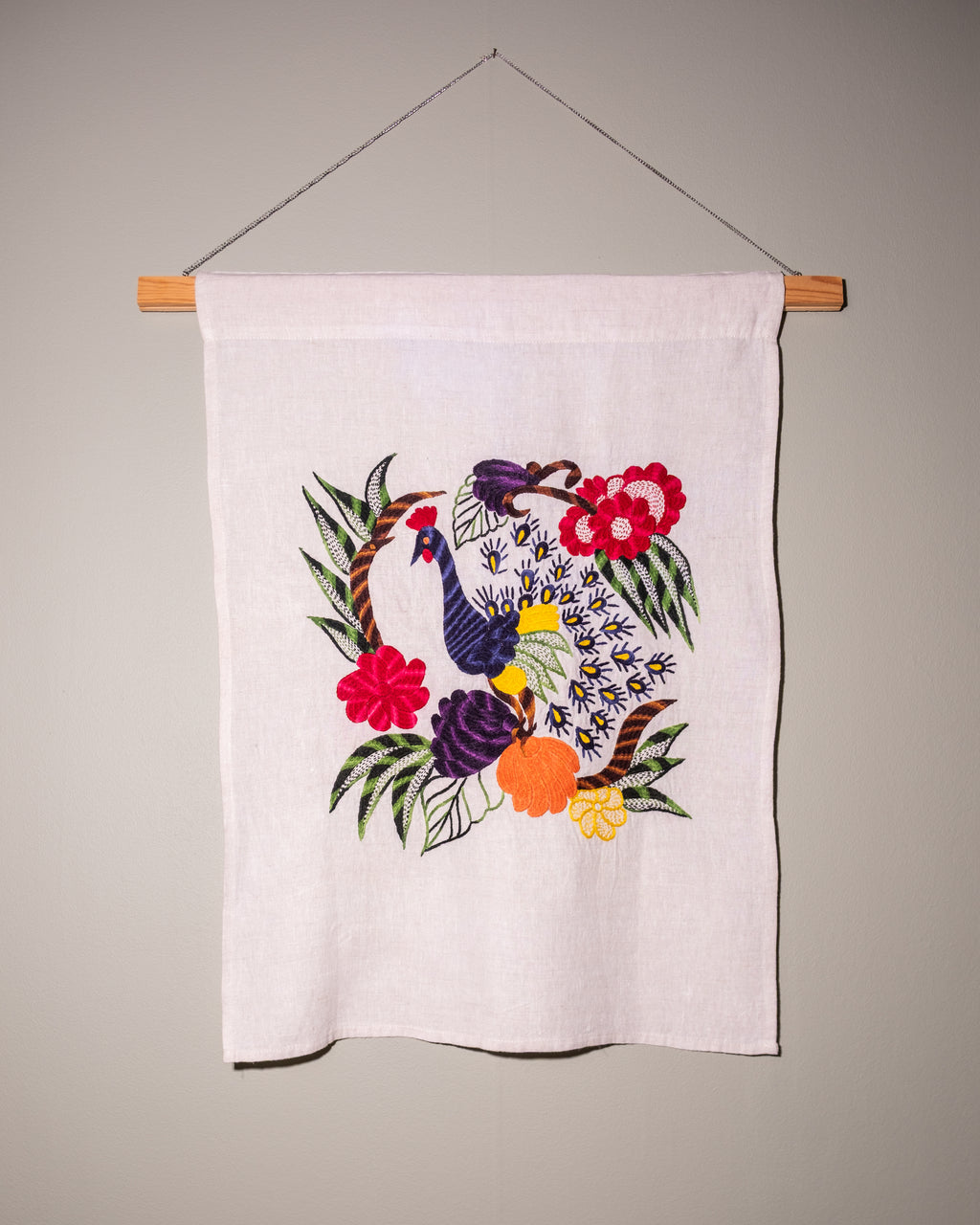Peacock wall hanging on natural linen
