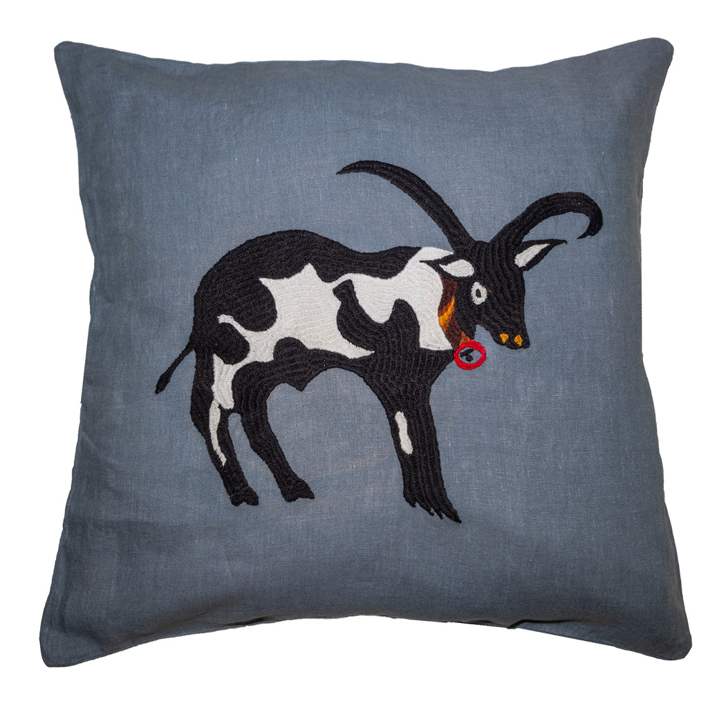 Cow pillow on blue linen