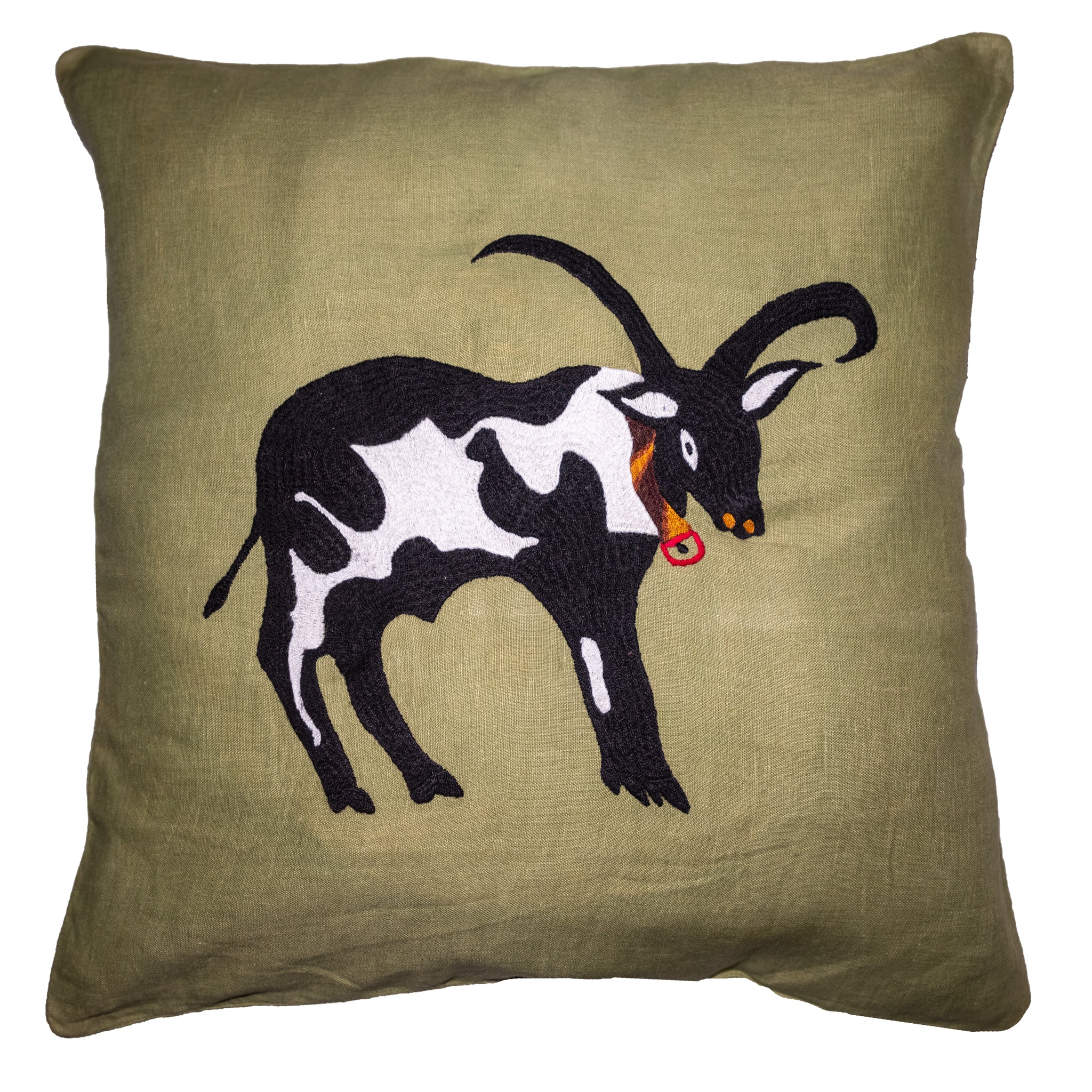 Cow pillow on green linen