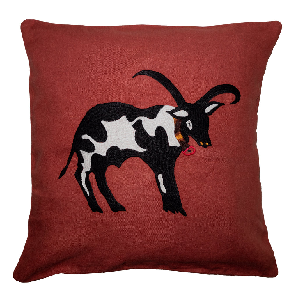 Cow pillow on red linen
